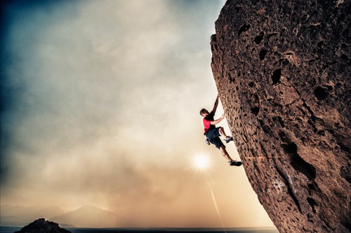 Man climbing rocky cliff